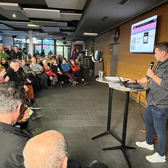 Bild enthält, People, Person, Crowd, Table, Desk, Shoe, Adult, Male, Man, Woman