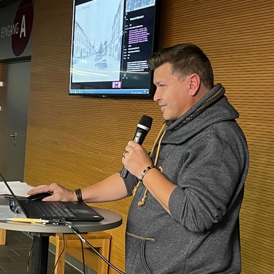 Bild enthält, Furniture, Table, Desk, Microphone, Crowd, Person, Adult, Male, Man, Laptop