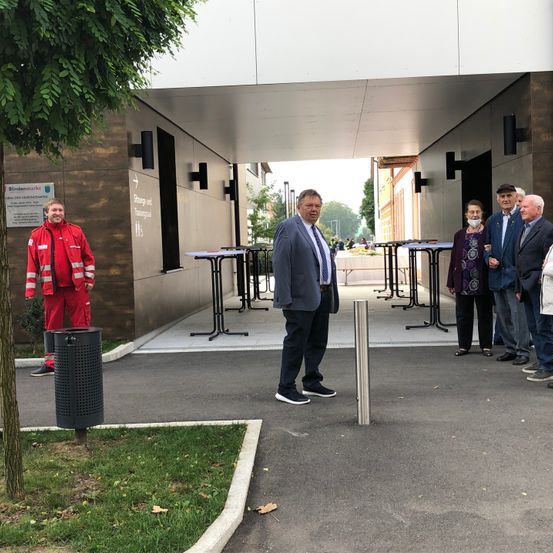 Bild enthält, Person, Coat, Jacket, Furniture, Table, Shelter, Jeans, Shoe, Desk, Suit