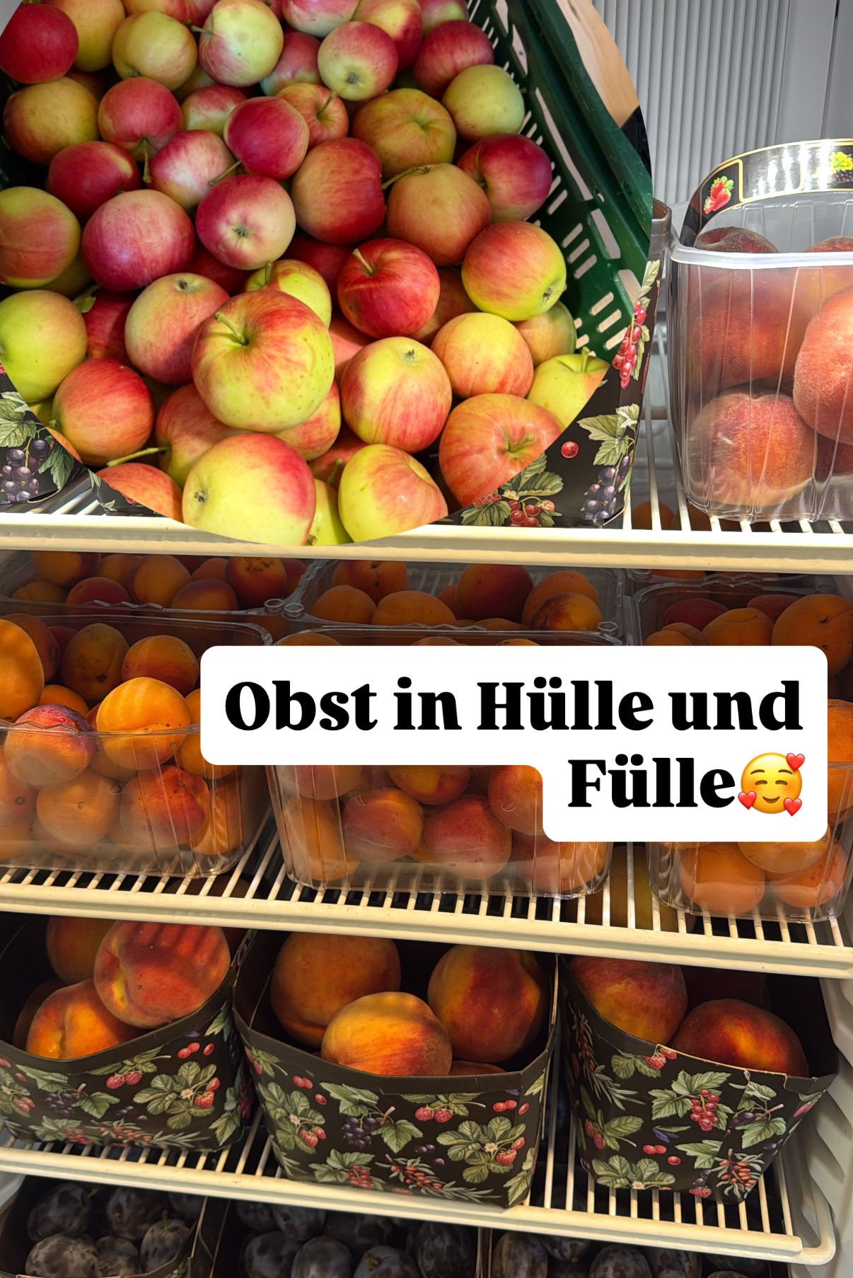 Eine Obstschau in einem Geschäft mit Äpfeln im oberen Korb und Pfirsichen in den unteren Körben. Die Bildunterschrift lautet 'Obst in Hülle und Fülle.'