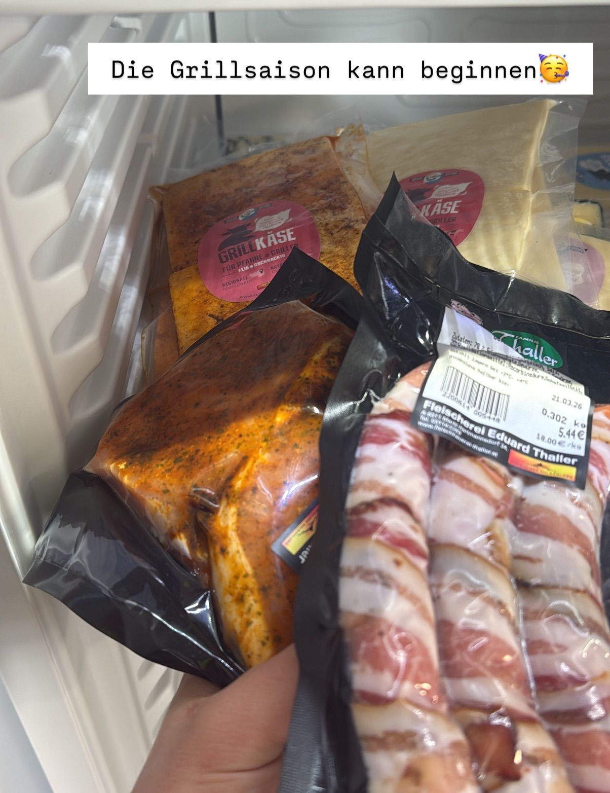 A closeup of various food items in a refrigerator, including a package of bacon, a meat dish in a black bag, and another bag of bacon. The bacon has a price tag of 5.44 euros.