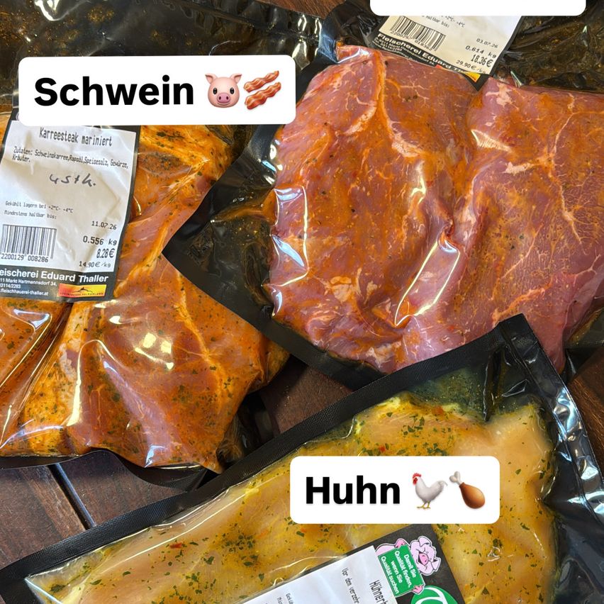 Three plastic bags of marinated meat on a wooden surface. The top bag has a label reading 'Schwein' and a pig emoji. The middle bag has a label with 'Huhn' and a chicken emoji. The bottom bag has a label with 'Hähnchen' and a chicken emoji.