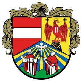 Ein Wappen mit zwei Männern und einem Vogel, einem Kreuz und einem Adler auf einem Schild. Der Adler hält ein Kreuz und ein Schwert. Der Hintergrund ist eine Kombination aus Rot, Gelb und Blau.