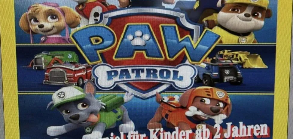 Plakat für Paw Patrol-Veranstaltung mit animierten Charakteren, darunter ein Hund, ein Auto und eine Polizeimütze. Es ist ein Puppenspiel für Kinder ab 2 Jahren, geplant für Mittwoch um 16 Uhr in Grafenschachen.
