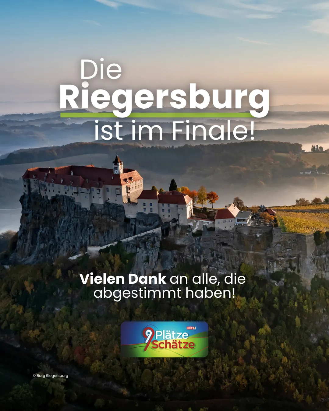 Eine Burg steht auf einem felsigen Felsvorsprung, umgeben von einer nebligen Landschaft. Die Burg hat ein rotes Dach und ist von Bäumen umgeben.
