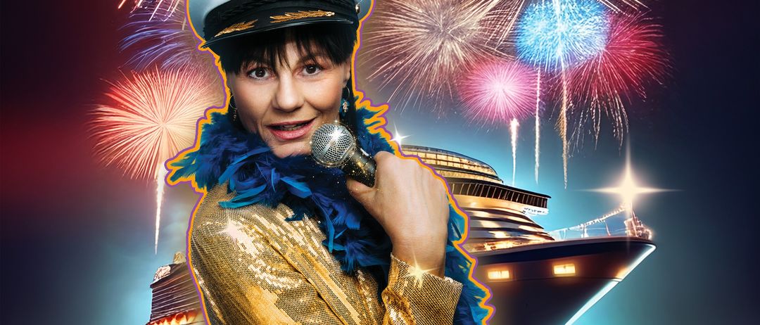 Eine Frau in einem goldglänzenden Kostüm mit Matrosenmütze hält ein Mikrofon mit Feuerwerk im Hintergrund. Ein Kreuzfahrtschiff liegt im Wasser.