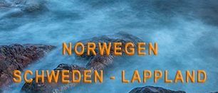 Eine landschaftliche Ansicht einer Küstenlandschaft mit einem Leuchtturm im Hintergrund, umgeben von Felsen und einem Gewässer. Der Himmel ist klar und blau, mit einigen Wolken sichtbar. In der Ferne gibt es mehrere Häuser, von denen eines rot gestrichen ist. Das Bild hat einen Wasserzeichen, der 'Multivision Wolfgang Fuchs' lautet.