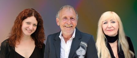 Drei Menschen, zwei Frauen und ein Mann, stehen lächelnd vor einem bunten Hintergrund. Der Mann trägt einen schwarzen Anzug mit einem silbernen Pik-Design.