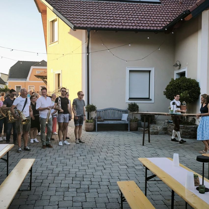 Blaskapelle spielt im Hof eines Hauses in Österreich, Männer mit Instrumenten