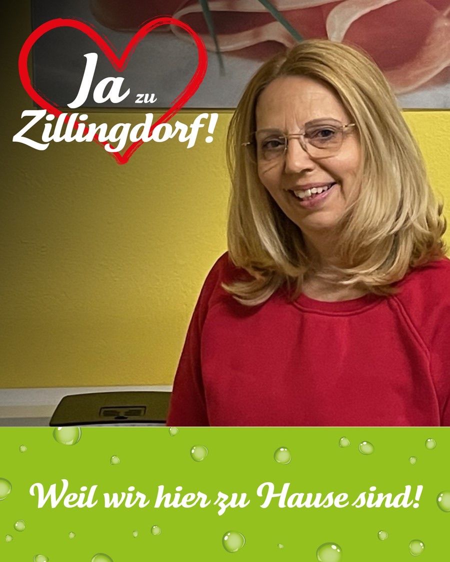 Eine lächelnde Frau mit blonden Haaren, die eine Brille und ein rotes Shirt trägt, steht vor einer gelben Wand mit einem roten Herz und Text.
