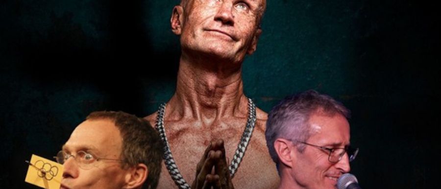 Drei Männer posieren vor einem Mikrofon und einer Gitarre. Ein Mann hat ein olympisches Symbol auf seinem Gesicht. Ein anderer Mann hat eine große Kette um den Hals.