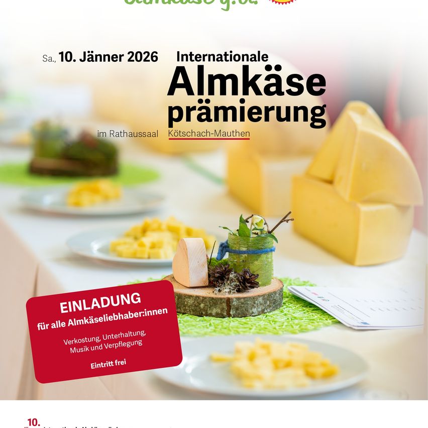 Werbung für die Internationale Almkase Premiere am 10. Januar 2026. Zeigt Käse, Teller und eine rote Einladungskarte. Gelegen in einem Speisesaal mit festlicher Atmosphäre.