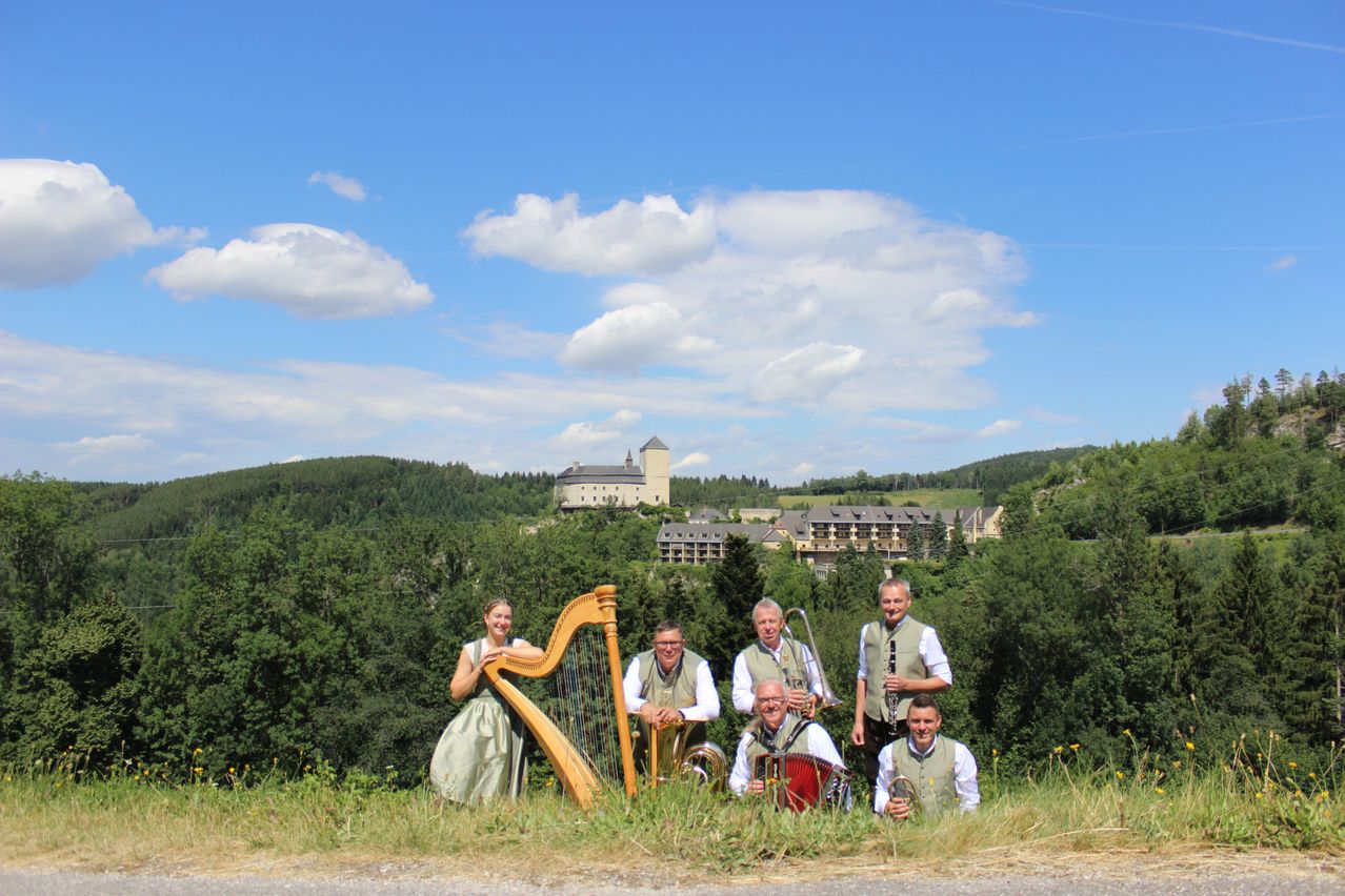 Musikgruppe mit Harfe und Blasintrumenten vor Schloss und Hotel in Niederösterreich