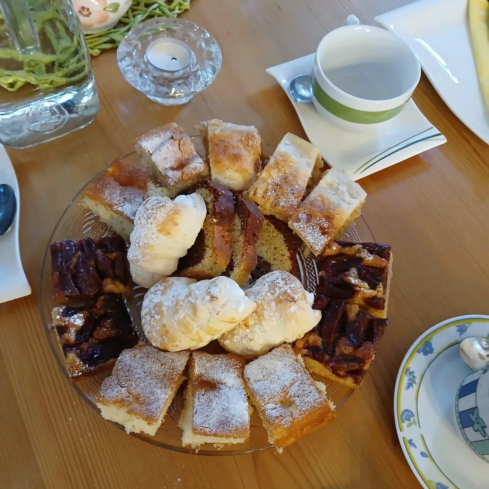 Ein Holztisch mit einem Teller verschiedener Desserts, darunter Gebäck, Kuchen und eine Kugel Eiscreme.