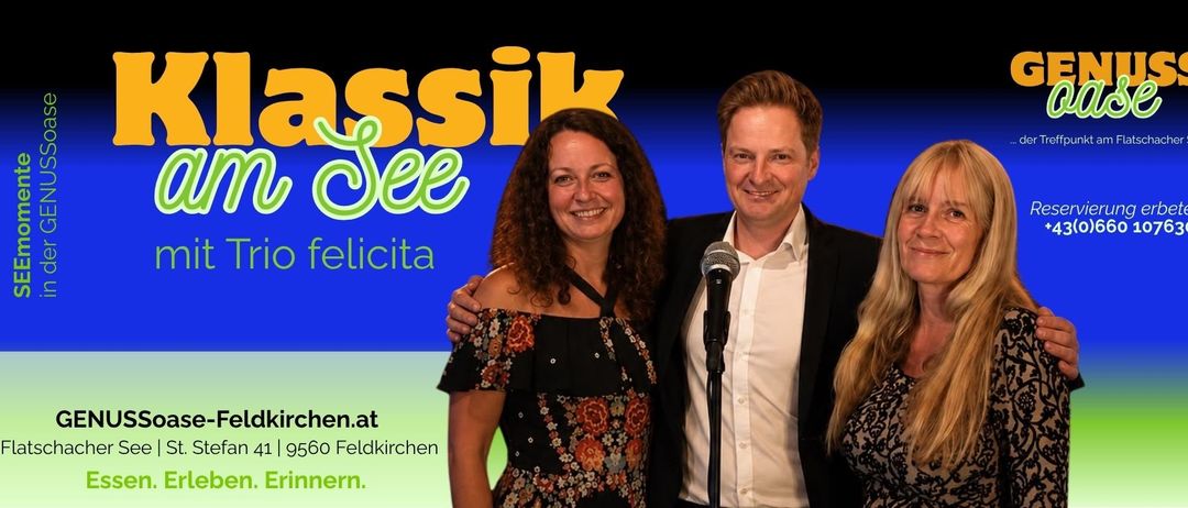 Eine lächelnde Frau in einem Blumenkleid und ein Mann im Anzug stehen gemeinsam vor einem Mikrofon. Der Hintergrund zeigt den Text 'ssik See' und 'licita'.