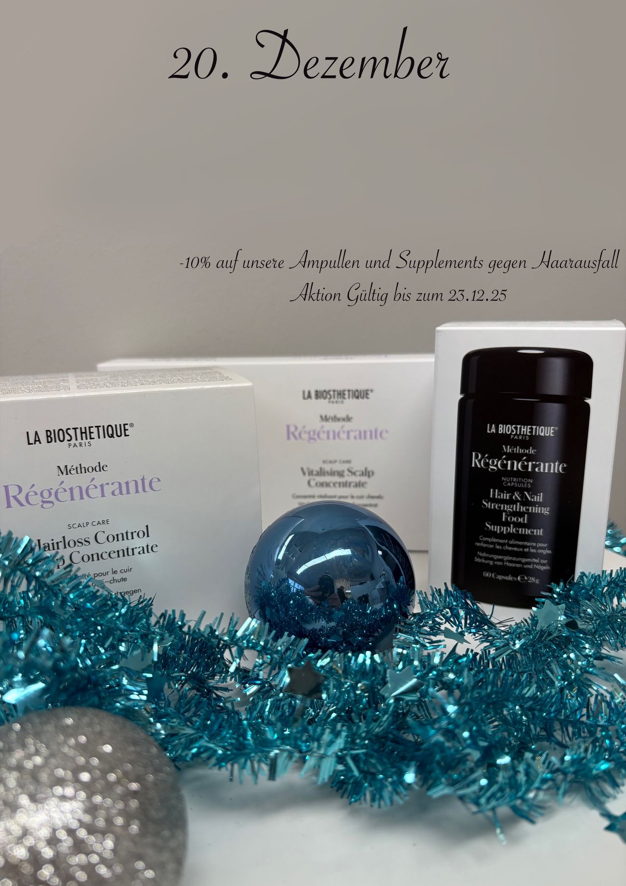 Eine Anzeige von La Biosthetique Produkten vor grauem Hintergrund. Die Produkte umfassen Haarverlust Kontrolle Konzentrat, Revitalisierendes Kopfhaut Konzentrat und Haar & Nagel Stärkungs Nahrungsergänzungsmittel. Ein blauer Tinsel-Hintergrund ist vorhanden.