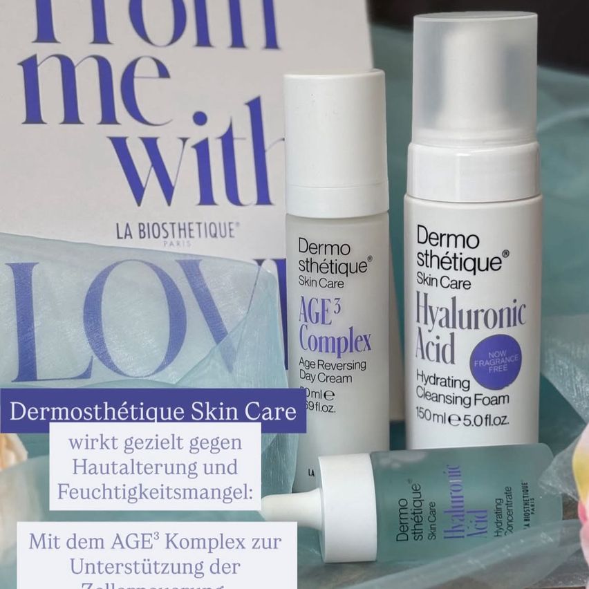 Verschiedene Hautpflegeprodukte von Dermo Sthetique auf blauem Hintergrund gezeigt. Ein Buch mit dem Titel 'Von mir mit Liebe' ist ebenfalls zu sehen.