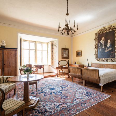 Bild enthält, Home Decor, Rug, Chandelier, Lamp, Furniture, Indoors, Living Room, Table, Person, Interior Design