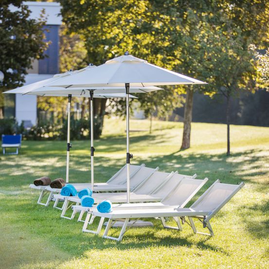 Bild enthält, Grass, Plant, Lawn, Housing, Patio, Patio Umbrella, Chair, Shoe, Outdoors, Canopy