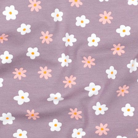 Eine Nahaufnahme eines weichen Stoffes mit einem Muster aus weißen und rosa Daisys auf einem lila Hintergrund. Die Blumen haben ein gelbes Zentrum und sind in einem verstreuten Muster angeordnet.