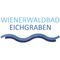 Das Logo von Wienerwaldbad Eichgraben zeigt eine blaue Welle auf weißem Hintergrund. Der Text ist fett und blau.