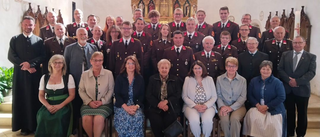 Eine Gruppe von Menschen in Uniform, möglicherweise ein Chor, posiert für ein Foto vor einem Altar in einer Kirche.