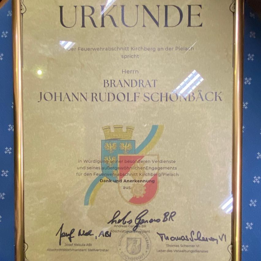 Ein Zertifikat mit goldenem Rahmen ehrt Johann Rudolf Schonback für seine besonderen Verdienste und herausragendes Engagement für die Feuerwehr Kirchberg/Pleiach. Es ist vom Bürgermeister der Stadt unterzeichnet.