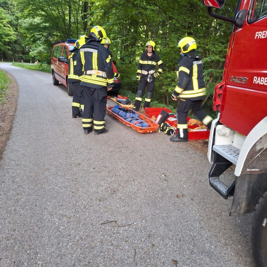 Rettungskräfte bereiten sich darauf vor, einen Patienten auf einer Trage von einem roten Feuerwehrauto zu transportieren.