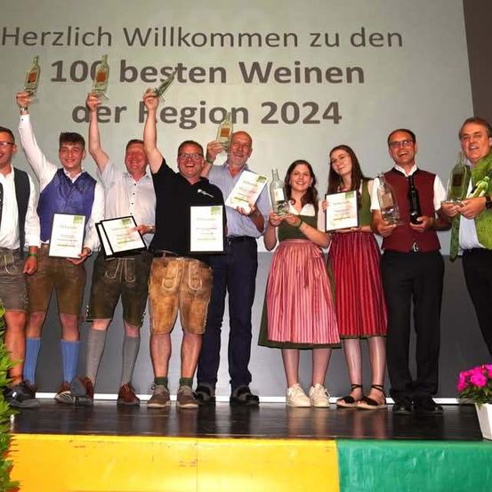 Bild enthält, Potted Plant, People, Person, Stage, Groupshot, Flower Arrangement, Adult, Male, Man, Skirt