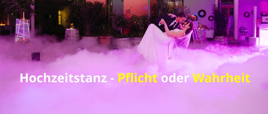 Eine Braut und ein Bräutigam tanzen zusammen mit lila Rauch um sie herum. Sie sind von Blumen und Pflanzen umgeben.