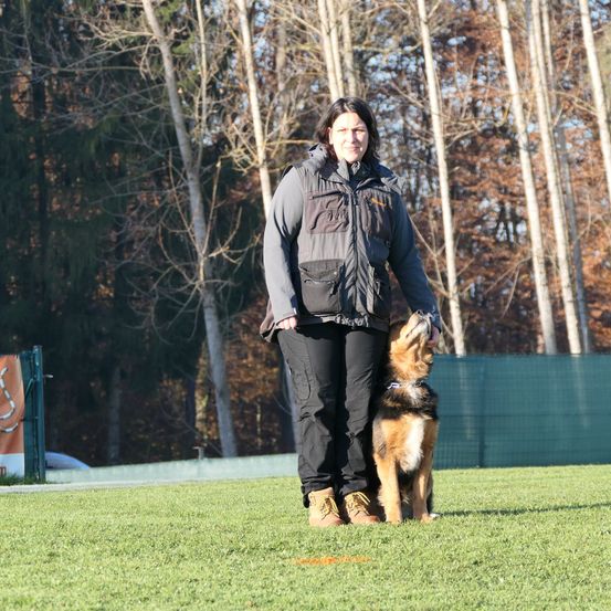 Bild enthält, Person, Coat, Jacket, Animal, Canine, Mammal, Pet, Shoe, German Shepherd, Face