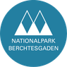 The logo for Nationalpark Berchtesgaden. A blue circle with three white triangles stacked vertically and the name written in white.