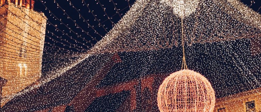 Eine festliche Szene mit zahlreichen leuchtenden Dekorationen über einem Gebäude, die eine funkelnde, magische Nachtatmosphäre erzeugen.