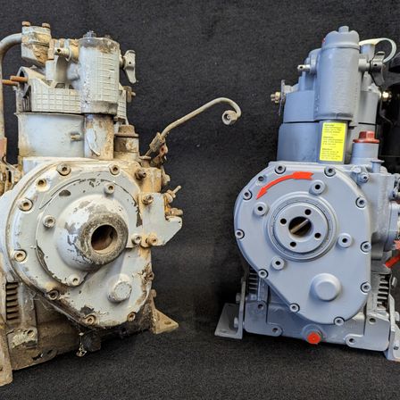 Zwei mechanische Motoren sind auf einem schwarzen Hintergrund abgebildet. Der linke Motor ist rostig und weist sichtbare Schäden auf. Der rechte Motor ist blau mit einem gelben Etikett und roten Pfeilen, die die Rotation anzeigen.