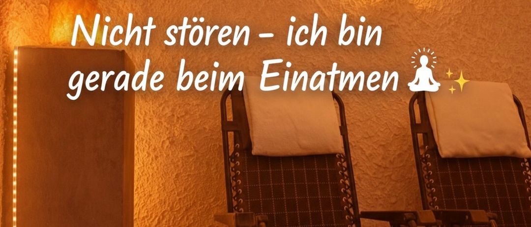 Ein ruhiger Raum mit einem entspannenden Stuhl, warmer Beleuchtung und einer Botschaft, die lautet 'Bitte nicht stören - ich atme gerade ein'.