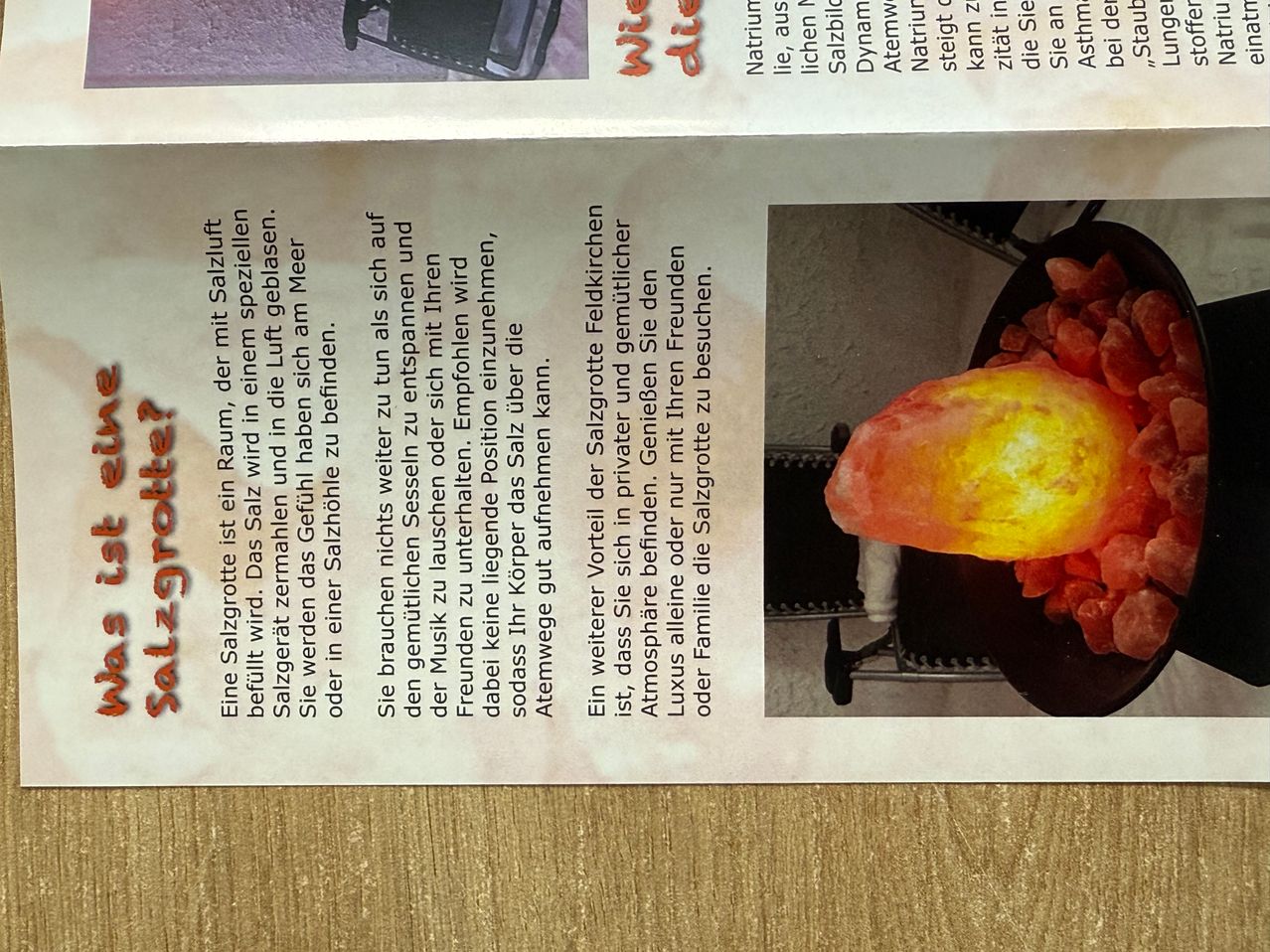 Eine Seitenansicht aus einer Zeitschrift mit einer leuchtenden Salzsteinlampe und einem schwarzen Metallständer. Der Text behandelt die Vorteile von Salzlampen.