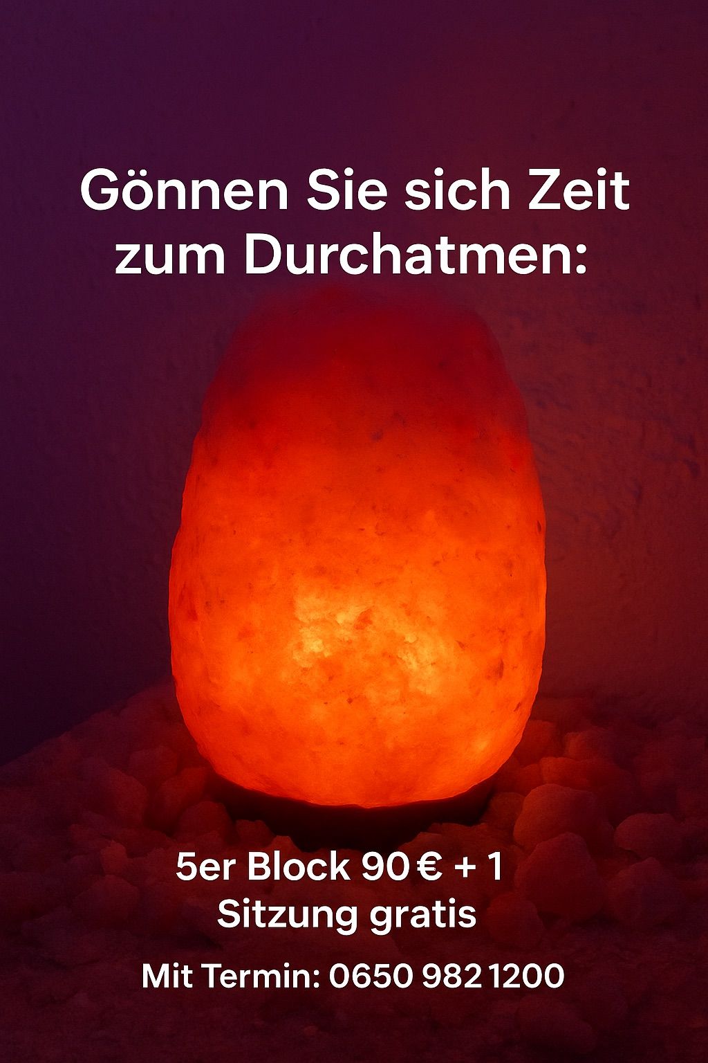 Eine leuchtend orangefarbene Himalaya-Salzlampe mit dem Text 'Nehmen Sie sich Zeit zum Durchatmen' darüber. Die Lampe steht auf einem Bett aus Steinen. Der Preis beträgt 90€ + 1.