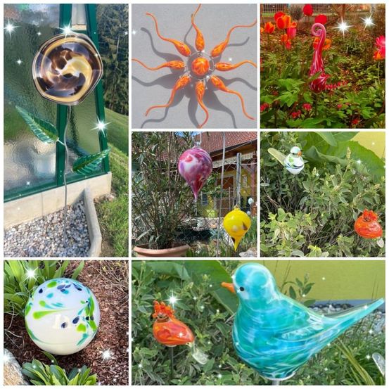 Eine Sammlung von farbenfrohen Glaskunstwerken, darunter eine Blume, eine Sonne, einen Vogel und eine Kugel. Jedes Stück ist in einer Gartenumgebung mit Grünpflanzen und dekorativen Lichtern ausgestellt.