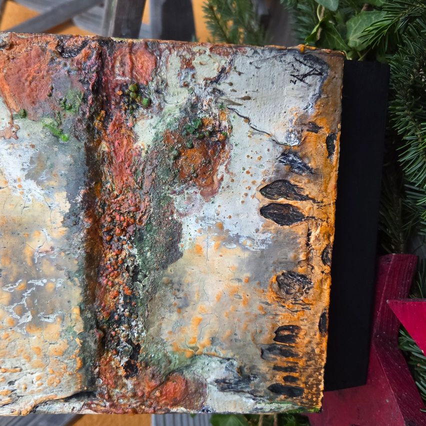 Eine Nahaufnahme eines abstrakten Gemäldes mit verschiedenen Texturen und Farben, vor einem grünen und roten Hintergrund dargestellt.