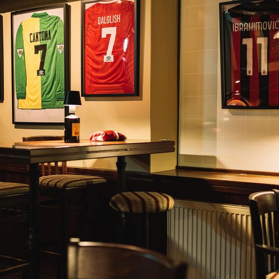 Bild enthält, Indoors, Interior Design, Dressing Room, Furniture, Table, Restaurant, Cafe, Chair, Text, Shop