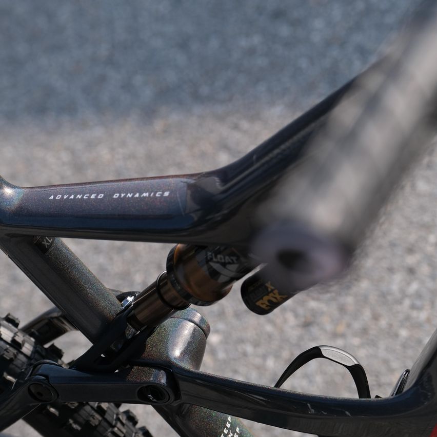 Eine Nahaufnahme eines Hochleistungs-Mountainbikes mit Advanced Dynamics-Markierung. Es hat einen schlanken, schwarzen Rahmen mit silbernen Akzenten.