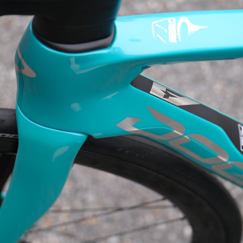 Eine Nahaufnahme eines blauen Fahrradrahmens mit schwarzem Lenker und Logo an der Seite.