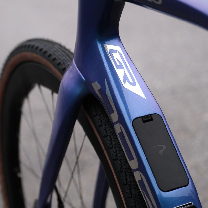 Nahaufnahme eines blauen Fahrrads mit einem weißen G2-Logo auf dem Rahmen und einem schwarzen Aufkleber am Sitzrohr.