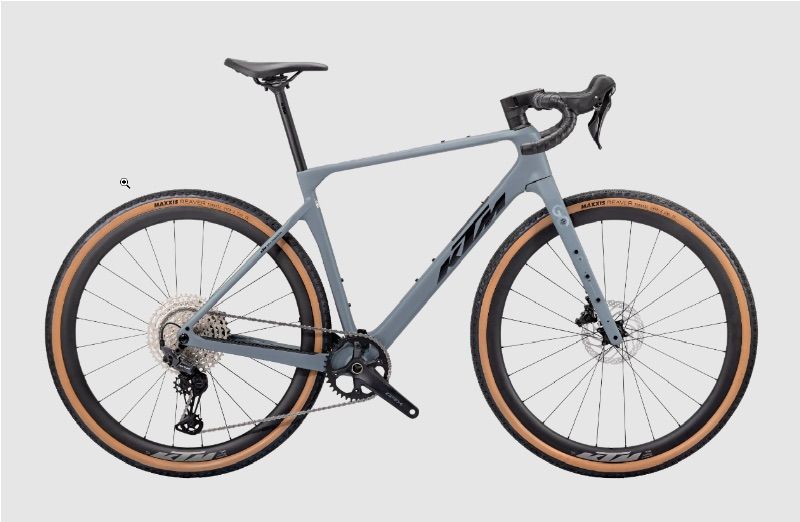 Ein graues Rennrad mit schwarzen und braunen Reifen, auf einem weißen Hintergrund dargestellt. Das Fahrrad hat ein schlankes Design mit einem schwarzen Sattel und Lenker.
