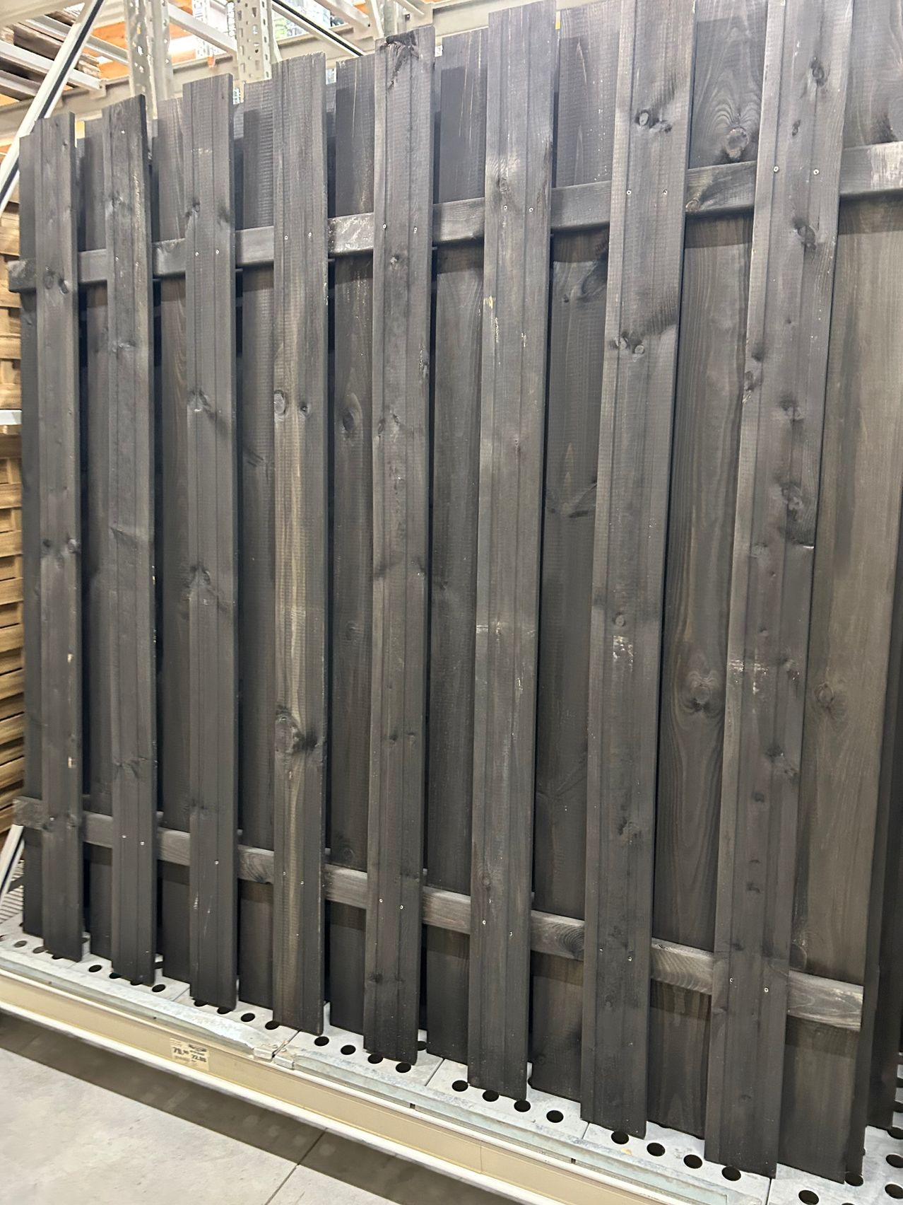 Ein Nahaufnahme einer hölzernen Zaun mit Kohlefinish, die verwitterte Bretter vertikal gestapelt zeigt.