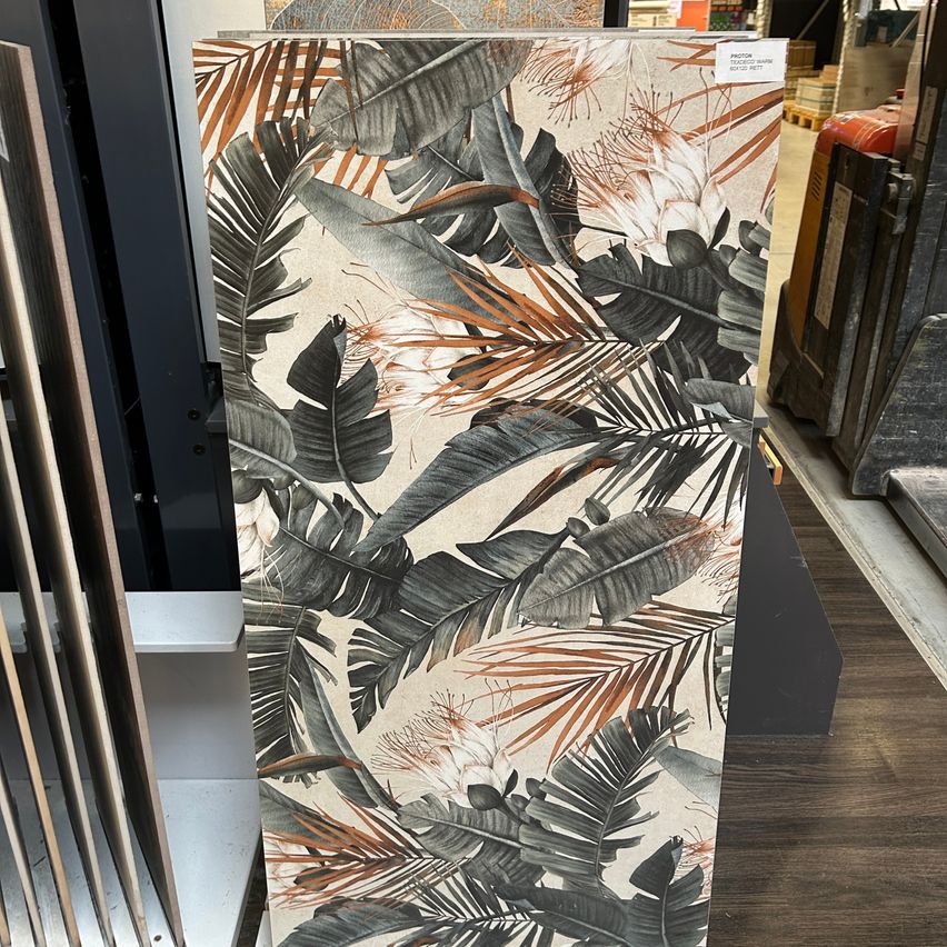 Eine Ausstellung von tropischen Blattmusterfliesen mit beigem Hintergrund und braunen Akzenten in einer Ladenumgebung.