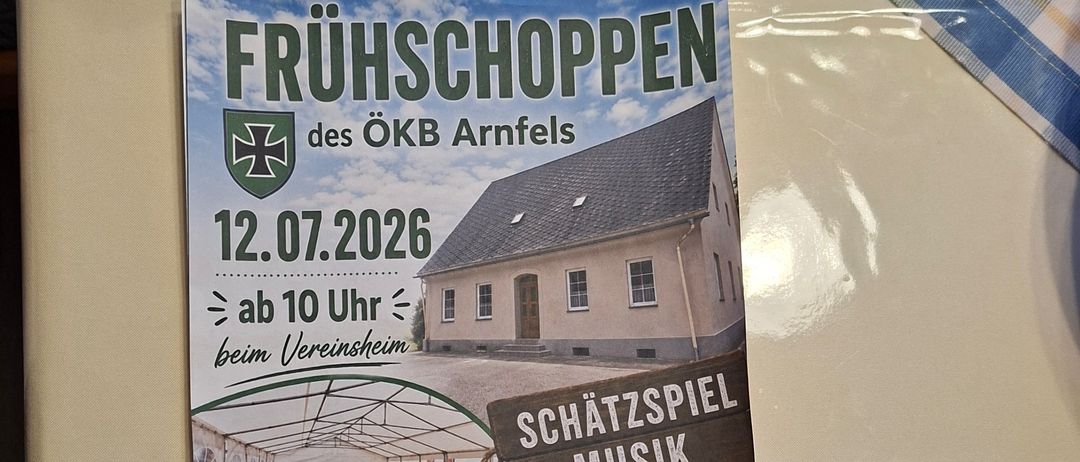 Ein Flyer für die Fruhschoppen-Veranstaltung bei OKB Arnfels, geplant für den 12. Juli 2026, mit einem Haus, einem Zelt, Musikinstrumenten und Essen auf Tischen.
