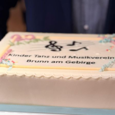 Ein Kuchen mit Musiknoten und dem Text 'Kinder Tanz und Musikverein Brunn am Gebirge' darauf geschrieben.