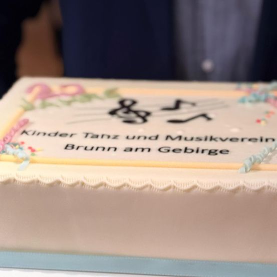 Ein Kuchen mit Musiknoten und dem Text 'Kinder Tanz und Musikverein Brunn am Gebirge' darauf geschrieben.