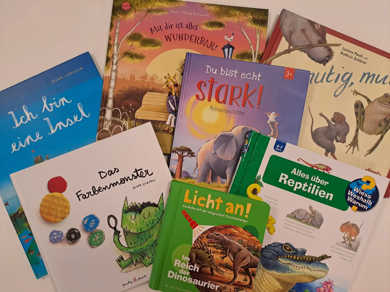 Eine Sammlung von Kinderbüchern mit verschiedenen Illustrationen und Titeln, einschließlich 'Mit dir ist alles wunderbar', 'Du bist echt stark!' und 'Alles über Reptilien'. Die Bücher haben lebhafte Einbände mit Tieren, Dinosauriern und bunten Illustrationen.